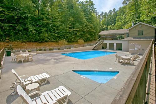 a patio with chairs and a swimming pool at Boulder Bear Lodge #355 in Pigeon Forge