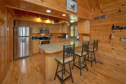 a kitchen with wooden cabinets and a island with bar stools at Boulder Bear Lodge #355 in Pigeon Forge