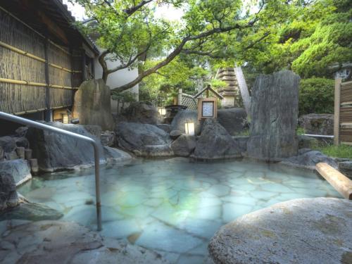 a hot tub in a garden with rocks at Hotel Yagi - Vacation STAY 25619v in Awara