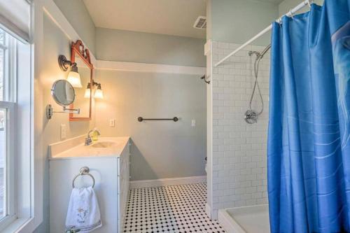a bathroom with a sink and a shower with a blue shower curtain at The Southport Cottage! in Southport