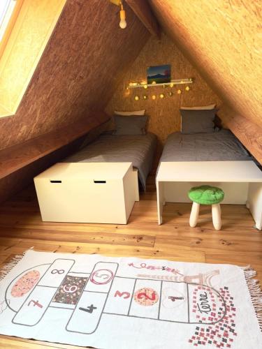 a attic bedroom with two beds and a rug at Saules et Têtards in Frasnes-lez-Anvaing