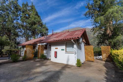 a small white house with a red roof at Parque San José - Héroes Parques in San José de Maipo