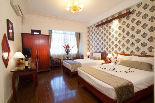 a hotel room with two beds and a window at Hanoi Luxury Hotel in Hanoi