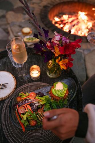 a table topped with a plate of food and flowers at Costanoa in Pescadero