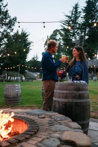 a man and a woman standing next to a fire pit at Costanoa in Pescadero