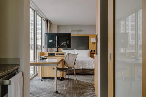 a hotel room with a bed and a desk with a computer at Club Quarters Hotel World Trade Center, New York in New York