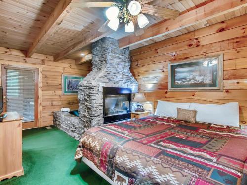 セバービルにあるCabin Fever #117の石造りの暖炉とベッド付きのベッドルーム1室