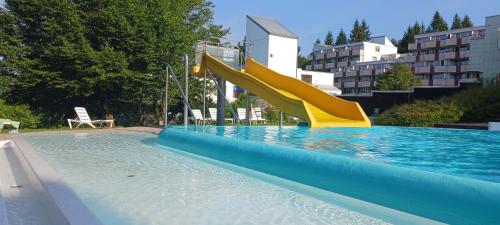 a swimming pool with a slide in a swimming pool at App MAJA Am Predigtstuhl in Sankt Englmar