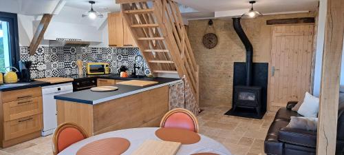 a kitchen with a stove and a kitchen with a table at Panarama maison neuve superbe vue in Gouffern en Auge