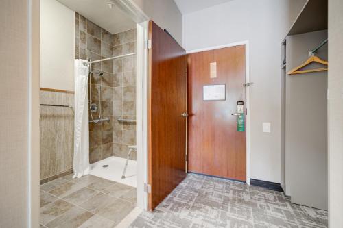 a bathroom with a shower and a wooden door at Holiday Inn West Yellowstone by IHG in West Yellowstone