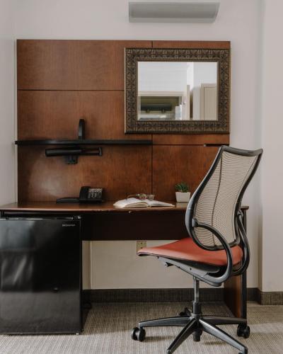 a desk with a chair and a mirror at Club Quarters Hotel Embarcadero, San Francisco in San Francisco