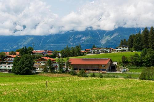a small town in a field with mountains in the background at Ferienwohnung am Bauernhof, Korbingerhof in Rinn