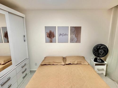 a bedroom with a bed with four pictures on the wall at Caminho do Mar - Apartamento com excelente localização in Rio das Ostras