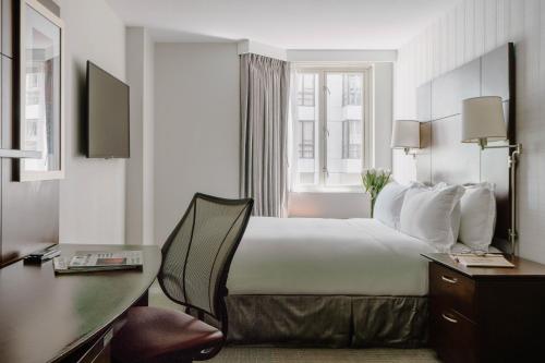a hotel room with a large bed and a desk at Club Quarters Hotel Embarcadero, San Francisco in San Francisco