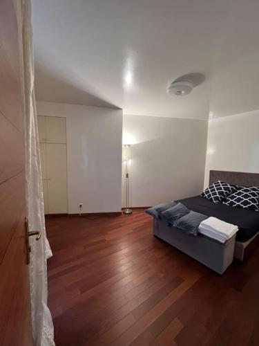 une chambre avec un lit et un parquet dans l'établissement Appartement calme paris, à Paris