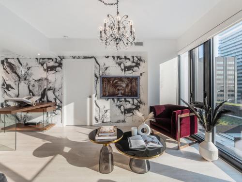 a living room with a chandelier and a couch at Hazelton Suites - Yorkville - Indoor Pool & Hot Tub in Toronto