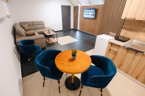 a living room with a table and blue chairs at Tara Apartments in Kolašin