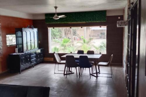 a dining room with a table and chairs and a window at Casa en la playa in Ciudad del Carmen