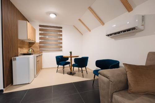 a kitchen and a living room with a table and chairs at Tara Apartments in Kolašin