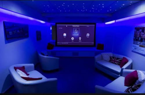 a blue room with couches and a large tv at La Bay Luxury Beach Bungalow in Puducherry