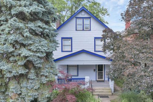 a white house with blue trim and trees at Housepitality - The Maynard Manor in Columbus
