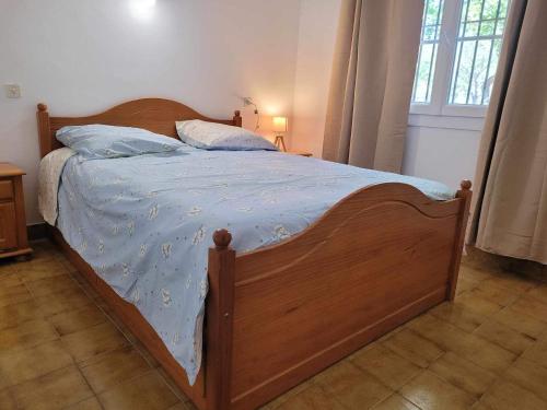 a bed with a wooden frame in a bedroom at Borie en Provence in Velleron