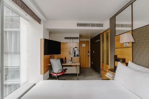a hotel room with a bed and a desk at The Jewel Hotel, New York in New York