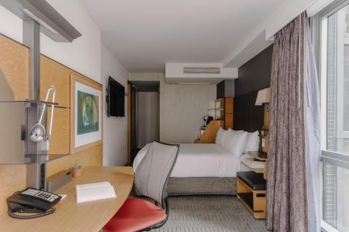 a hotel room with a bed and a desk at The Jewel Hotel, New York in New York