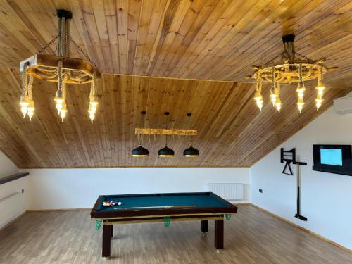 a pool table in a room with a wooden ceiling at Luxury Milan Mountain Ponoramic Villa, indoor heated pool and jacuzzi with mountain view in Gabala