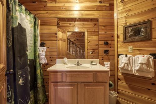 a bathroom with a sink in a wooden cabin at Farmers Retreat #221 in Sevierville