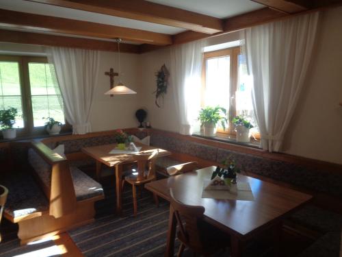 un restaurante con mesas, sillas y ventanas en Jogglerhof en Ramsau im Zillertal