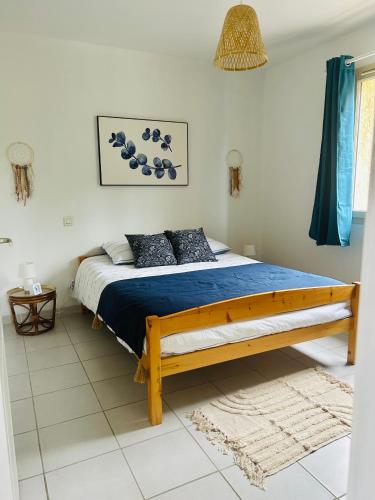 une chambre avec un lit avec une couette bleue dans l'établissement Maison Les Cammazes, à Les Cammazes