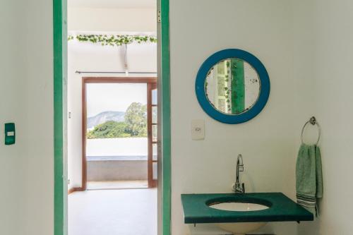 a bathroom with a green sink and a mirror at La Bohème Casa Cultural - Santa Teresa in Rio de Janeiro