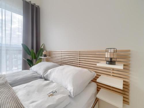 Cette chambre comprend un lit avec des oreillers blancs et une fenêtre. dans l'établissement Apartment in Dziwnów near sandy beach, à Dziwnów