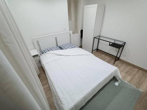 une petite chambre avec un lit et une table dans l'établissement Maison athis-mons, à Athis-Mons