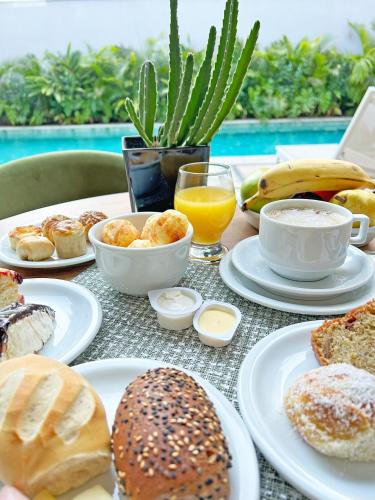 a table topped with plates of breakfast foods and drinks at Apartamentos Studio Allure Moema - Com café da manhã opcional, Recepção e Valet 24 horas in Sao Paulo