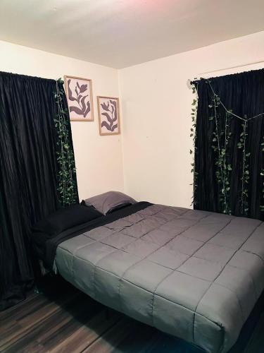 a bedroom with a bed with black drapes at Zen Home in Santa Ana