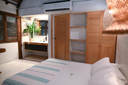 a bedroom with a bed and a bathroom with a sink at Hotel Playa Scondida Barú in Baru
