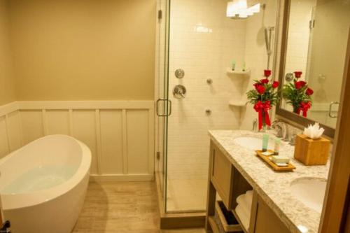 a bathroom with a tub and two sinks and a shower at The Ocean Lodge in Cannon Beach