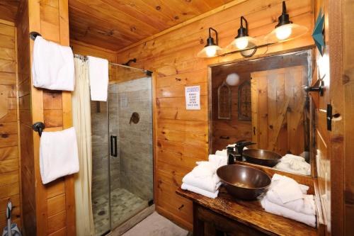 a bathroom with two sinks and a shower in a log cabin at Jackson's Starry Nite Sky #217 in Sevierville