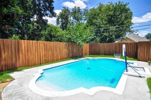 a swimming pool in a backyard with a wooden fence at Winnetka Heights Hideaway in Dallas