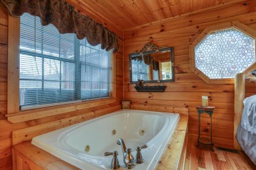 a large white tub in a wooden bathroom with a window at Kissing Retreat #269 in Sevierville