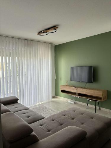 un salon avec un canapé et une télévision à écran plat dans l'établissement Appartement T2 Moderne, à Saint-Priest