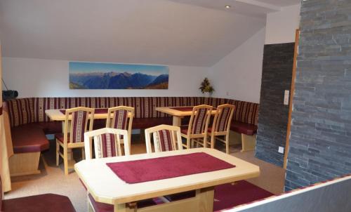 a dining room with tables and chairs and mountains at Apart Birgit in Kappl