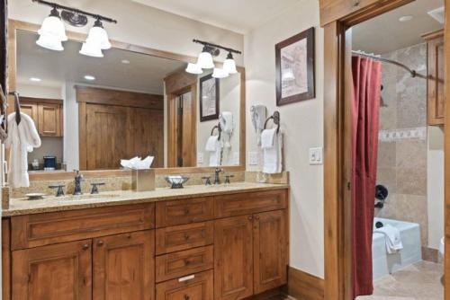 Un baño con dos lavabos y un espejo grande. en The Charter at Beaver Creek G415, en Beaver Creek