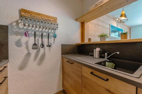- une cuisine avec évier et ustensiles sur le mur dans l'établissement Chamonix Sud - Jonquilles 138 - Happy Rentals, à Chamonix-Mont-Blanc