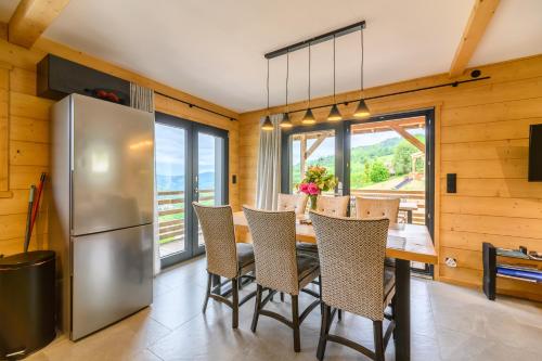 - une salle à manger avec un réfrigérateur et une table avec des chaises dans l'établissement Le Chalet Milien, à La Bresse