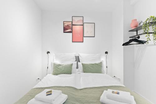 Un dormitorio blanco con una cama con dos toallas encima. en WHONAP - PINK LION I Parkplatz I Zentral I Terrasse I Küche I Business, en Neckarsulm