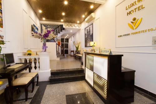 a lobby of a salon with a desk and chairs at Hanoi Luxury Hotel in Hanoi