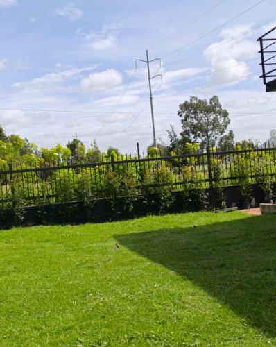 a fence in a yard with green grass at Comfort Campestre in Tabio